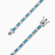 The Lab Grown Blue and White Diamond Tennis Bracelet in 14K White Gold features alternating round blue and white diamonds set in a continuous line, shown against a white background.