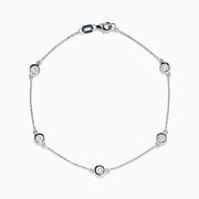 The 14K White Gold Bezel Diamond Bezel Bracelet features five round diamond-like stones in bezel settings, evenly spaced along a delicate chain, and secured with a lobster clasp.
