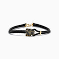 A black braided leather bracelet featuring a signature 14K yellow gold panther center with black diamond and tsavorite accents, finished with a gold clasp for men.
