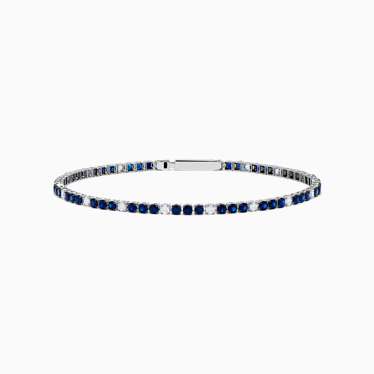 The Royale Bleu 14K White Gold Tennis Bracelet features alternating round blue sapphires and diamonds set in a slim band with a simple clasp, shown on a white background.