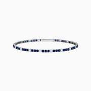 The Royale Bleu 14K White Gold Tennis Bracelet features alternating round blue sapphires and diamonds set in a slim band with a simple clasp, shown on a white background.