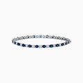 The Royale Bleu 14k White Gold Blue Sapphire and Diamond Bracelet showcases alternating round blue sapphires and clear diamonds in a continuous line, beautifully set against a plain white background.