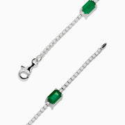 The 14K White Gold Emerald and Diamond Tennis Bracelet features a silver chain with small round white stones and five evenly spaced rectangular emeralds, displayed on a white background.