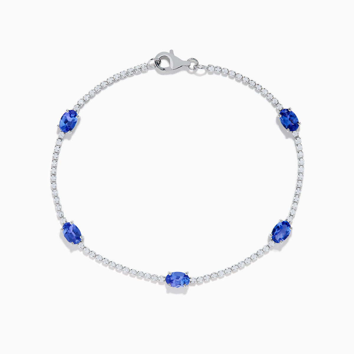 The Nahla Siri 14K White Gold Tanzanite and Diamond Tennis Bracelet features five oval tanzanite gemstones set among sparkling diamond accents in a delicate design with a secure clasp.