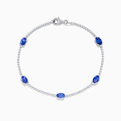 The Nahla Siri 14K White Gold Tanzanite and Diamond Tennis Bracelet features five oval tanzanite gemstones set among sparkling diamond accents in a delicate design with a secure clasp.