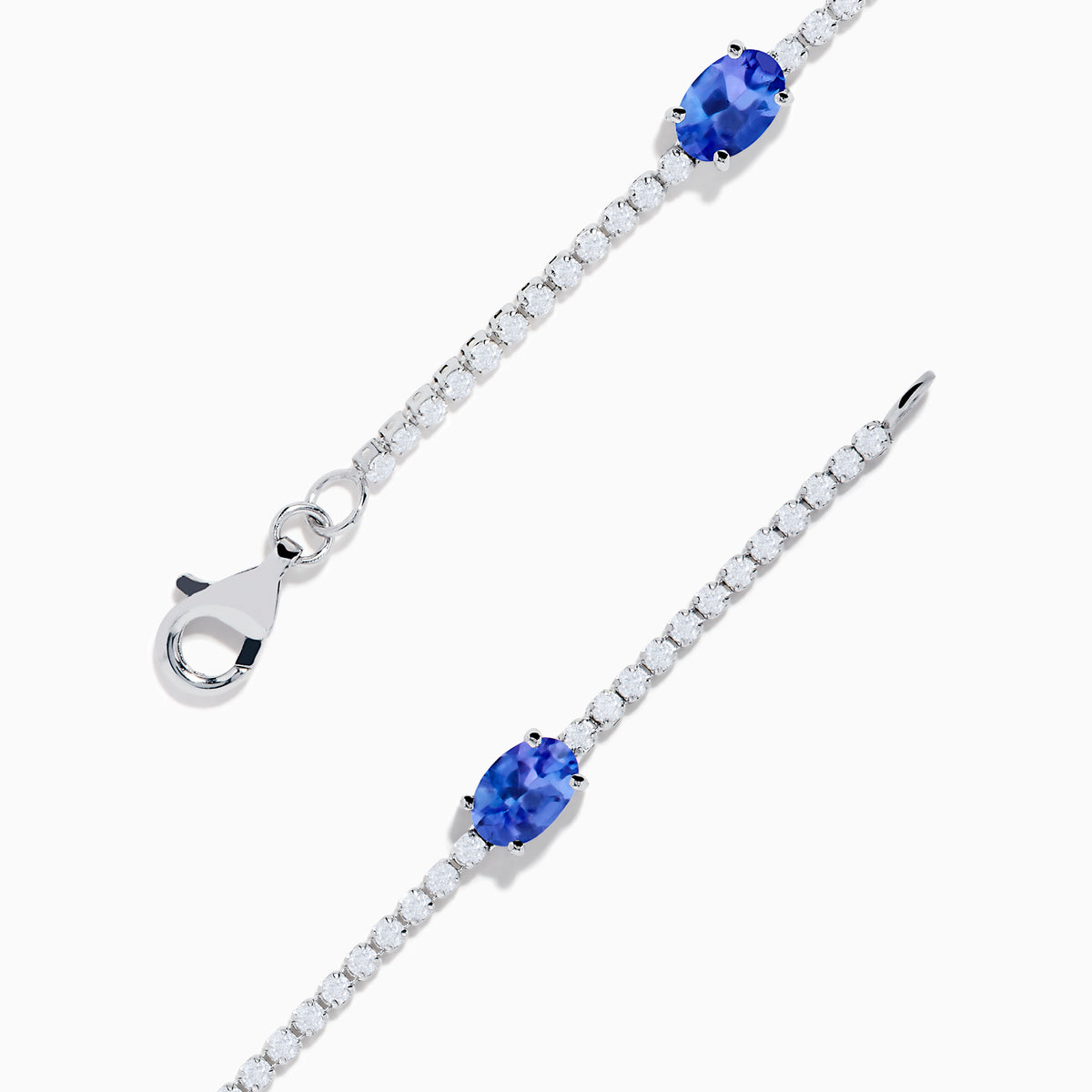 The Nahla Siri 14K White Gold Tanzanite and Diamond Tennis Bracelet features five oval tanzanite gemstones set among sparkling diamond accents in a delicate design with a secure clasp.