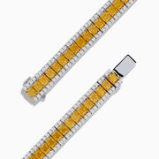 The Canare 18K Two Tone Gold White & Yellow Diamond Bracelet, showcasing a central row of yellow diamonds bordered by clear stones, is elegantly displayed on a white background.