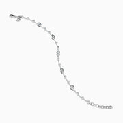 The 14K White Gold Diamond Station Bracelet features small round and teardrop-shaped diamonds spaced along a thin chain, showcased on a white background.