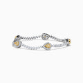 The 18K Two Tone Gold Yellow and White Diamond Station Tennis Bracelet features sparkling white diamonds and three striking yellow and white diamond stations, each outlined by smaller diamonds in an elegant, detailed design.