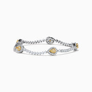 The 18K Two Tone Gold Yellow and White Diamond Station Tennis Bracelet features sparkling white diamonds and three striking yellow and white diamond stations, each outlined by smaller diamonds in an elegant, detailed design.