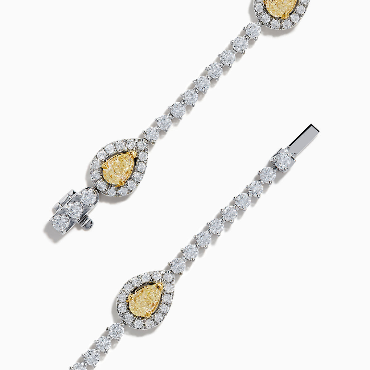 The 18K Two Tone Gold Yellow and White Diamond Station Tennis Bracelet features sparkling white diamonds and three striking yellow and white diamond stations, each outlined by smaller diamonds in an elegant, detailed design.