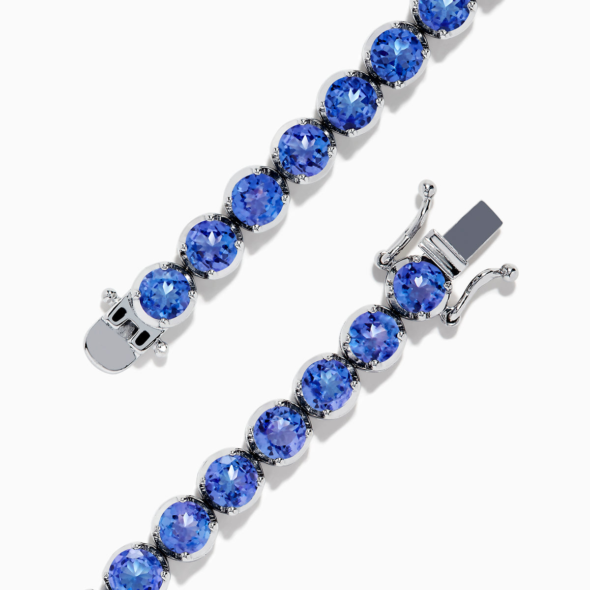 The Nahla Siri Sterling Silver Tanzanite Tennis Bracelet showcases a row of round, faceted tanzanite gemstones in prong settings, elegantly displayed against a white background.