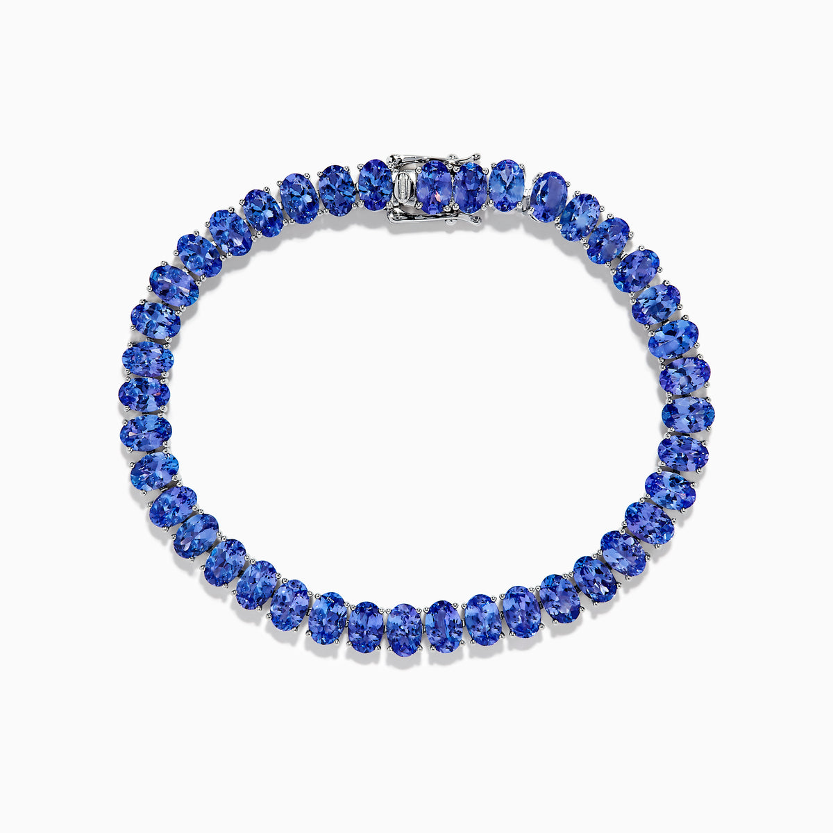 The Nahla Siri Sterling Silver Oval Tanzanite Tennis Bracelet showcases a continuous row of oval-cut tanzanite gems set in sterling silver with a sleek clasp, displayed against a white background.