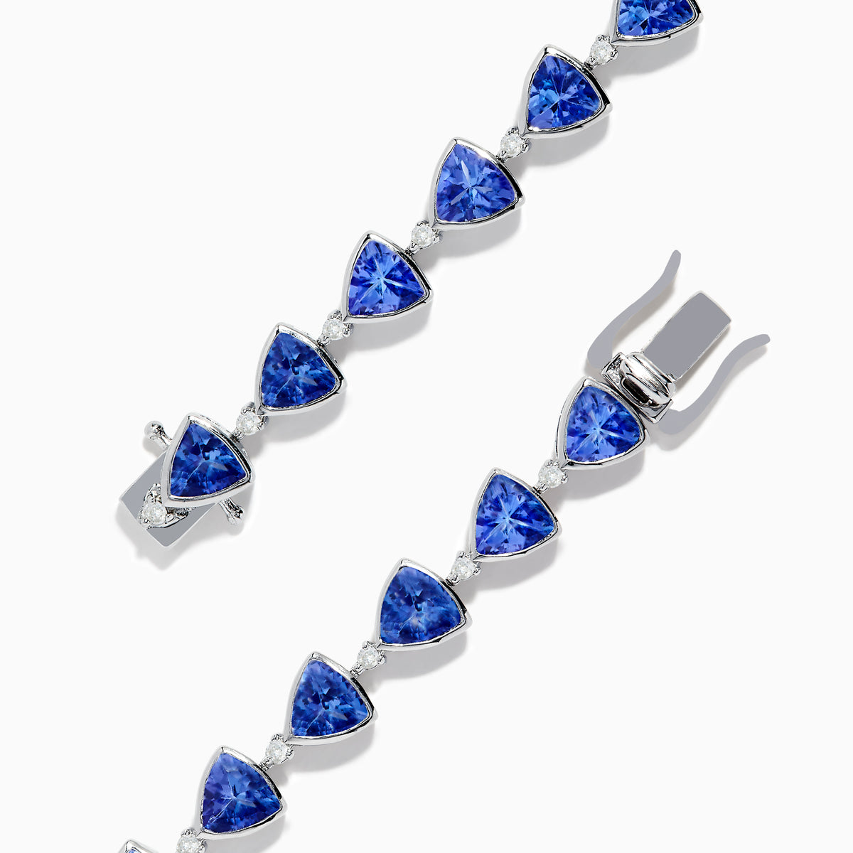The Nahla Siri Sterling Silver Tanzanite and Diamond Tennis Bracelet features triangular blue gemstones and diamonds set in sterling silver, evenly spaced and connected, shown against a white background.