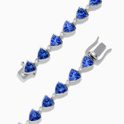 The Nahla Siri Sterling Silver Tanzanite and Diamond Tennis Bracelet features triangular blue gemstones and diamonds set in sterling silver, evenly spaced and connected, shown against a white background.