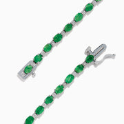 The 925 Sterling Silver Emerald and Diamond Tennis Bracelet features a continuous row of oval green gemstones and diamonds, each prong-set for elegance, reminiscent of an emerald bracelet, displayed on a white background.