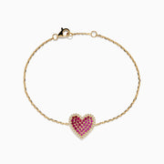 The Novelty 14K Yellow Gold Ruby, Pink Sapphire and Diamond Heart Bracelet features a heart-shaped pendant with pink sapphires, rubies, and diamonds on a delicate gold chain, shown against a plain white background.