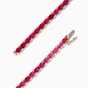 A slim 14k rose gold tennis bracelet featuring oval pink tourmalines and rubies totaling 6.56 TCW, set in a single row and displayed on a white background.
