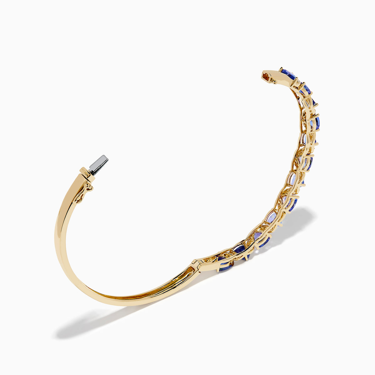 The Nahla 14K Yellow Gold Tanzanite and Diamond Bangle features alternating triangular tanzanite stones and sparkling diamonds in a repeating pattern along the gold band.