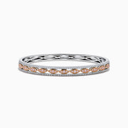 The 14K Two-Tone Gold Pink and White Diamond Bangle features marquise-shaped rose gold accents with pink gemstones, bordered by round white diamonds and an intricate inner openwork design.
