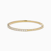 The DOro 14K Yellow Gold Diamond Bangle features a single row of sparkling white diamonds, expertly crafted in radiant yellow gold and elegantly displayed against a white background.