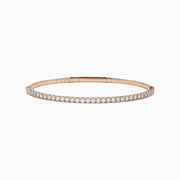 The Pave Rose 14K Rose Gold Diamond Bangle features a slim band adorned with a single row of sparkling white diamonds, set all around its circumference and shown on a white background.