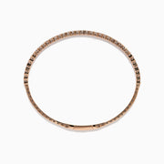 The Pave Rose 14K Rose Gold Diamond Bangle features a slim band adorned with a single row of sparkling white diamonds, set all around its circumference and shown on a white background.