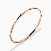The Pave Rose 14K Rose Gold Diamond Bangle features a slim band adorned with a single row of sparkling white diamonds, set all around its circumference and shown on a white background.