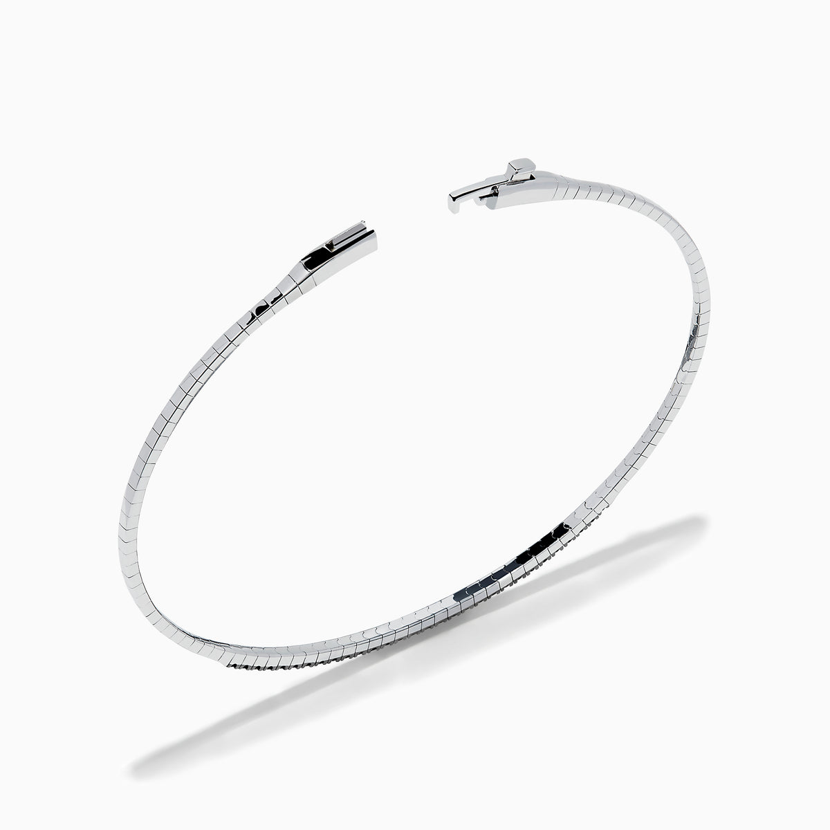 The Caviar 14K White Gold Black Diamond Bangle is a slim silver bracelet adorned with a row of small black diamonds, reminiscent of caviar, displayed on a white background.