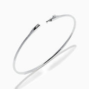 The Classique 14K White Gold Flexible Diamond Bangle features a sleek, minimalist design with a polished finish and a thin row of sparkling diamonds along the top half for effortless elegance.