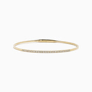 The D'Oro 14K Yellow Gold Pave Diamond Flexible Bangle features a slim, flexible design with a row of sparkling pave diamonds along the top half, shown against a plain white background.