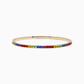 The Watercolors 14K Yellow Gold Multi Sapphire Bangle features a slim yellow gold band adorned with a row of rainbow-hued sapphires along the outer edge, shown on a white background.