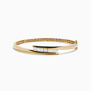 The D'Oro 14K Yellow Gold Channel Set Diamond Bangle features an open design with channel set round white diamonds on a horizontal bar and an inner band with an elegant lattice pattern.