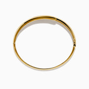 The D'Oro 14K Yellow Gold Channel Set Diamond Bangle features an open design with channel set round white diamonds on a horizontal bar and an inner band with an elegant lattice pattern.