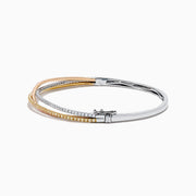 The 18K 3-Tone Gold White, Yellow and Pink Diamond Criss Cross Bangle features three intertwined rows of white, yellow, and pink diamonds set in an elegant, polished design.