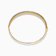 The D'Oro 14K Yellow Gold Diamond Bangle showcases rows of sparkling center diamonds, a textured border, and a secure hinged clasp for timeless elegance.
