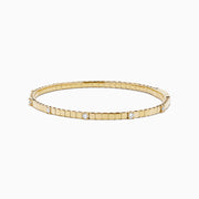 The 14K Yellow Gold Diamond Station Flexible Bangle features smooth rectangular links and evenly spaced round diamonds, offering minimalist elegance in a thin, flexible design perfect for any occasion.