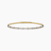 The 14K Two Tone Gold Diamond Station Flex Bangle features round white diamonds set along the top half, shown on a white background.