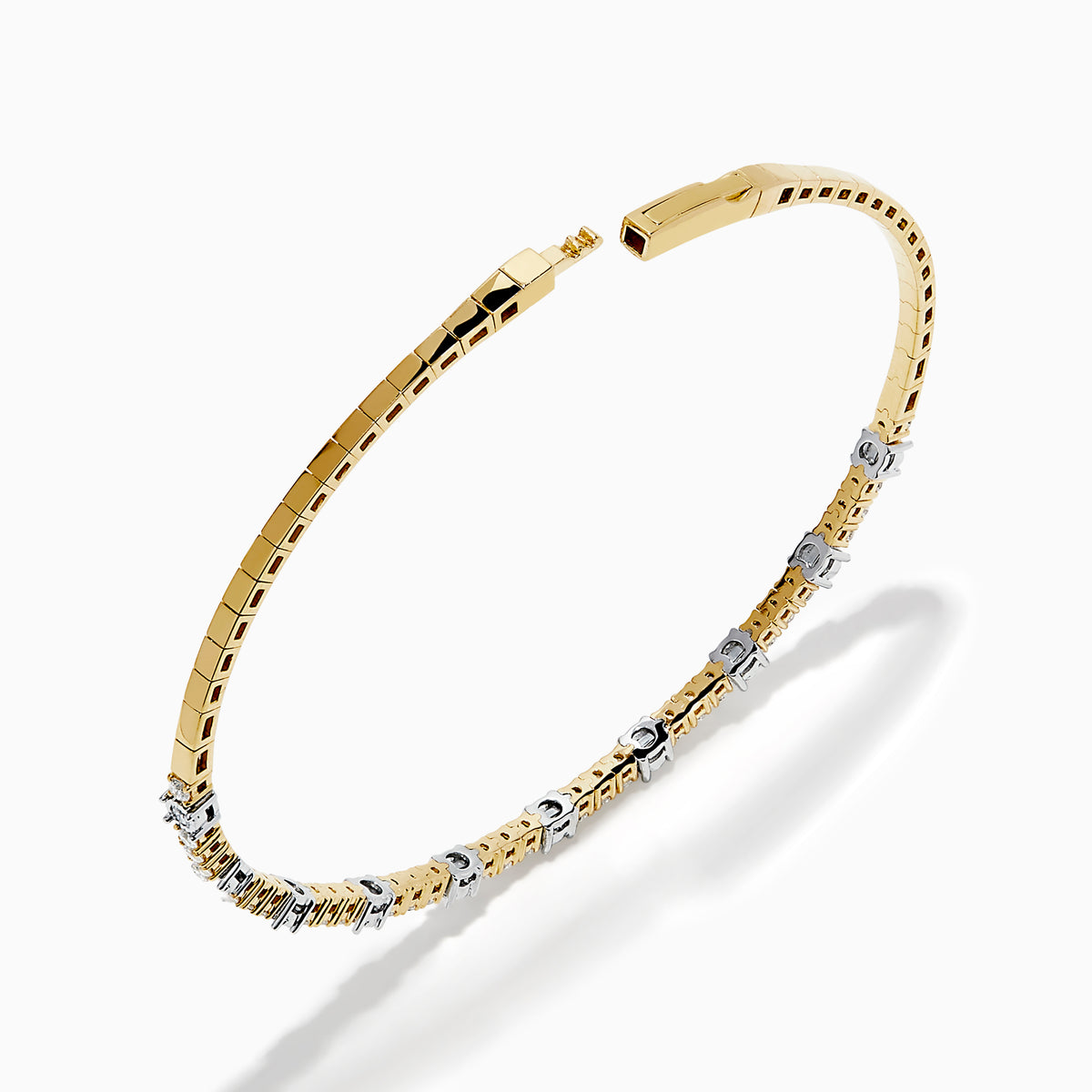 The 14K Two Tone Gold Diamond Station Flex Bangle features round white diamonds set along the top half, shown on a white background.