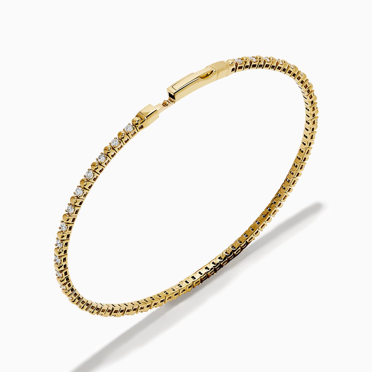 The 14K Yellow Gold Diamond Flex Bangle features a single row of sparkling white diamonds and a secure clasp, presented against a white background.