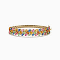 The Watercolors 14K Yellow Gold Multi Sapphire Bangle features marquise-cut sapphires in blue, green, pink, orange, and yellow, set in a leaf-inspired pattern, evoking the look of vibrant watercolors.