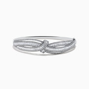 The Classique 14K White Gold Diamond Crossover Bangle features a twisted knot design with sparkling diamonds, shown against a plain white background.