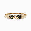 The Signature 14K Yellow Gold Diamond and Emerald Panther Bangle features two emerald-eyed panther heads facing each other, joined by a gold ring set with sparkling diamonds.