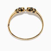 The Signature 14K Yellow Gold Diamond and Emerald Panther Bangle features two emerald-eyed panther heads facing each other, joined by a gold ring set with sparkling diamonds.