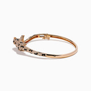 The Signature 14K Rose Gold Diamond and Emerald Panther Bangle features a panther design with its head and tail meeting at the front, adorned with sparkling diamonds and emeralds.