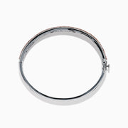 The 14K Two Tone Gold Pink and White Diamond Bangle features an intricate cutout design, accented by a central band with sparkling pink and white diamonds.