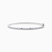 The 14K White Gold Diamond Spike Bangle showcases alternating pyramid studs and rows of sparkling diamonds on its sleek silver surface, set against a plain white background.