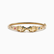 The Signature 14K Yellow Gold Multi Sapphire and Diamond Panther Bangle features two interlocking panther head motifs at the center, adorned with colorful sapphires and small diamonds.