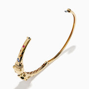The Signature 14K Yellow Gold Multi Sapphire and Diamond Panther Bangle features two interlocking panther head motifs at the center, adorned with colorful sapphires and small diamonds.