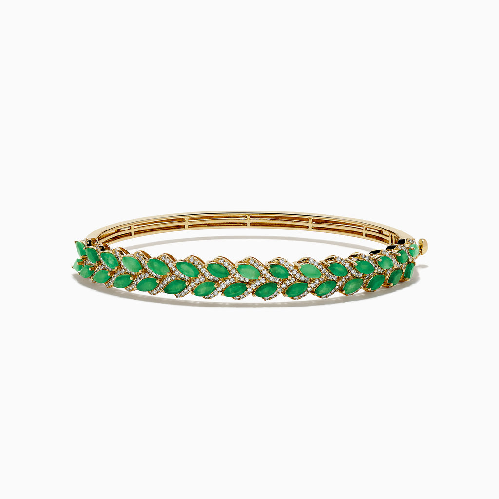 The 14K Yellow Gold Emerald and Diamond Marquise Leaf Bangle showcases an intricate leaf design with alternating emeralds and diamonds set along the band.